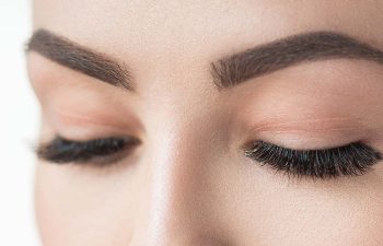 Close-up of closed woman's eyes and eyebrows.